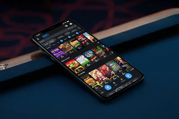 Uma jovem relaxando com o celular enquanto elementos dinâmicos de cassino flutuam ao seu redor, ilustrando a experiência móvel fluida oferecida pelo app 83W.