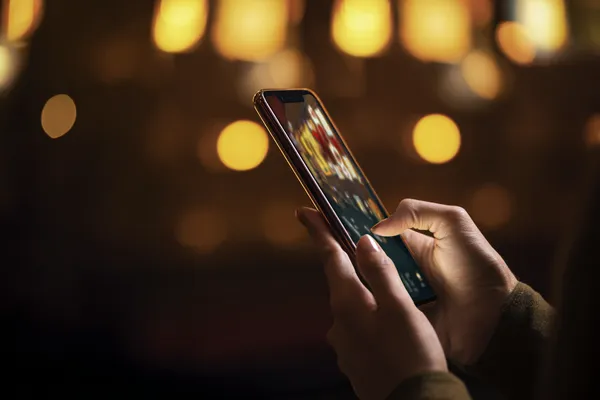 Uma mulher sorrindo perto de máquinas caça-níqueis brilhantes com símbolos de sorte, mostrando as emocionantes opções de slots do 83W.